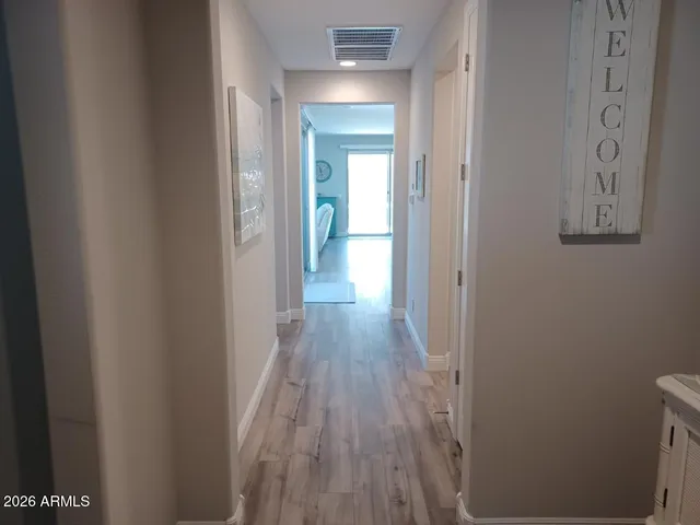 a view of a hallway with wooden floor