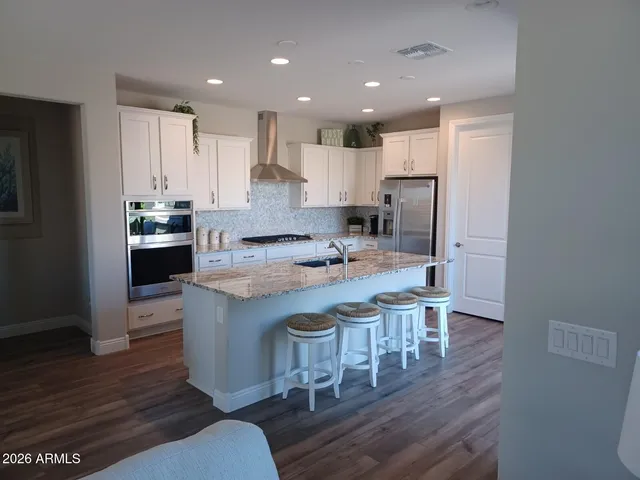 a kitchen with kitchen island granite countertop a sink and stove