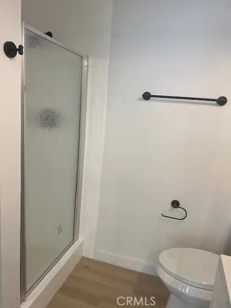 a bathroom with a granite countertop toilet and a shower