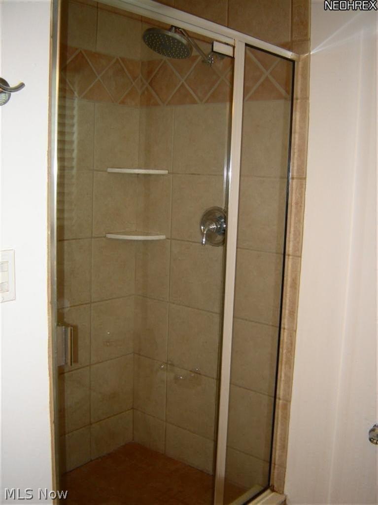 4048 Conover Road University Heights, OH 44118 - Photo 17 of 24 Wonderful walk-in shower stall with decorative tile accents, rain style shower head and shower seat.