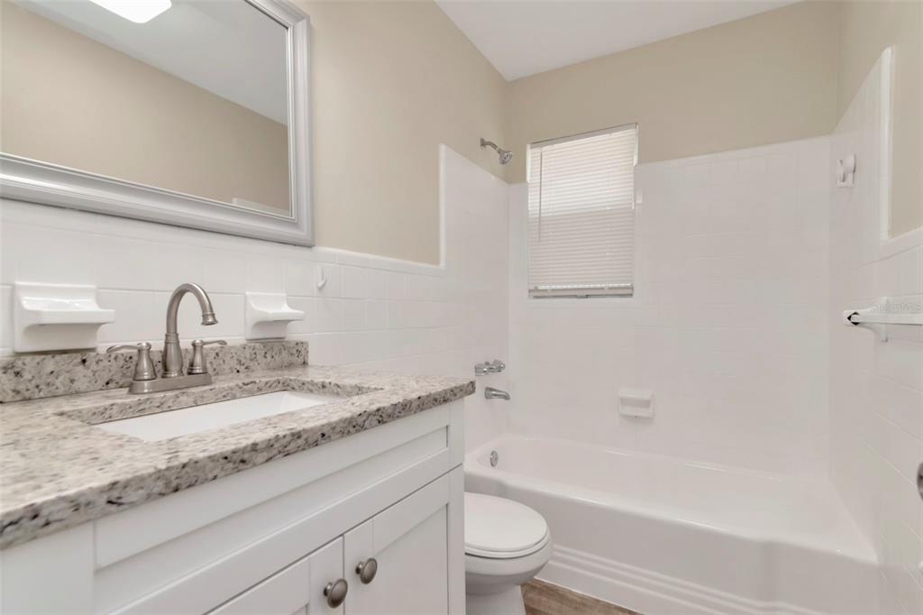 126 Kingsway Road Brandon, FL 33510 - Photo 24 of 42 a bathroom with a granite countertop sink toilet and bathtub