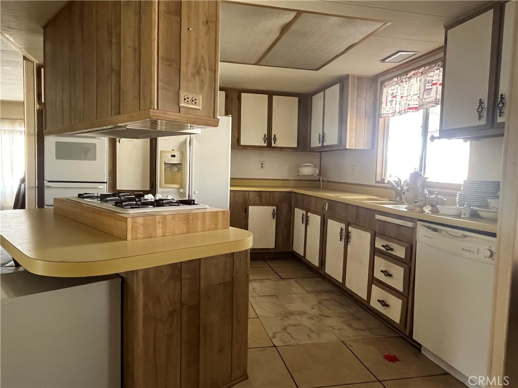 9391 California Avenue, Unit 109 Riverside, CA 92503 - Photo 3 of 9 a kitchen with stainless steel appliances granite countertop a sink a stove and cabinets