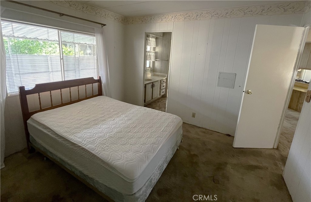9391 California Avenue, Unit 109 Riverside, CA 92503 - Photo 7 of 9 a bed sitting in a bedroom next to a window