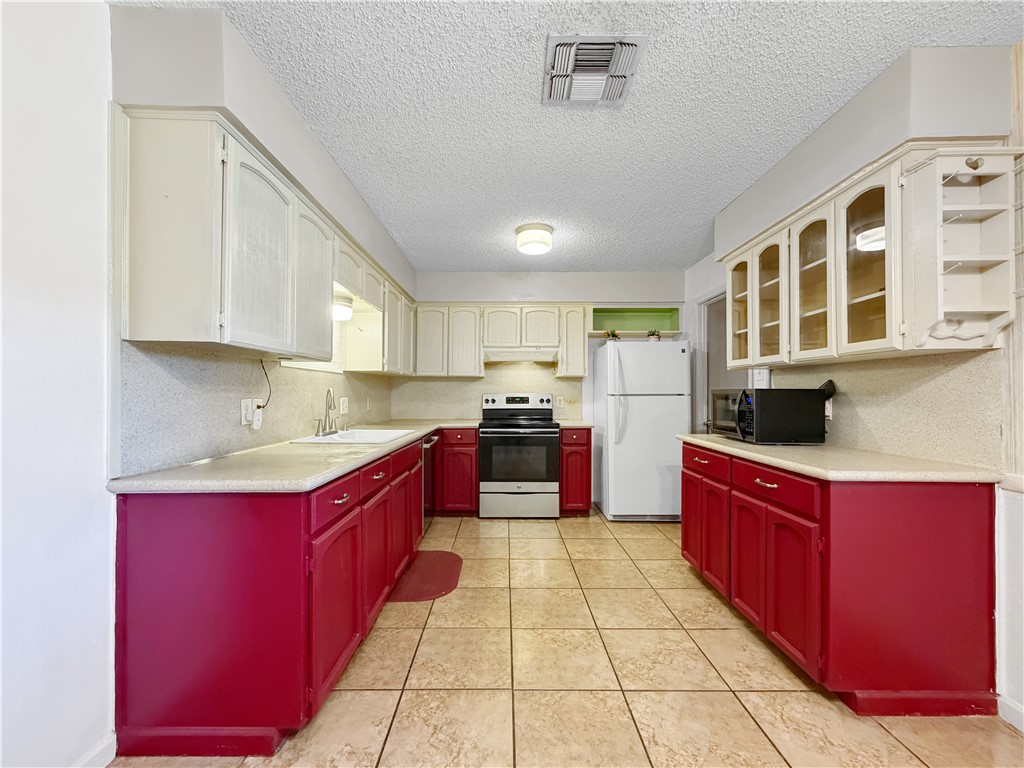910 Twite Circle Corpus Christi, TX 78418 - Photo 11 of 39 a large kitchen with stainless steel appliances granite countertop a stove sink and cabinets