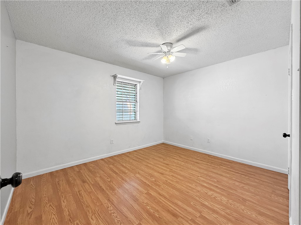 910 Twite Circle Corpus Christi, TX 78418 - Photo 25 of 39 an empty room with wooden floor fan and windows