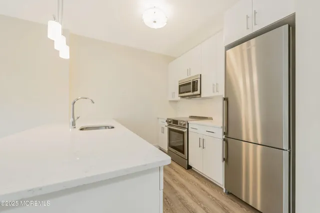 a kitchen with a refrigerator a stove top oven a sink and dishwasher