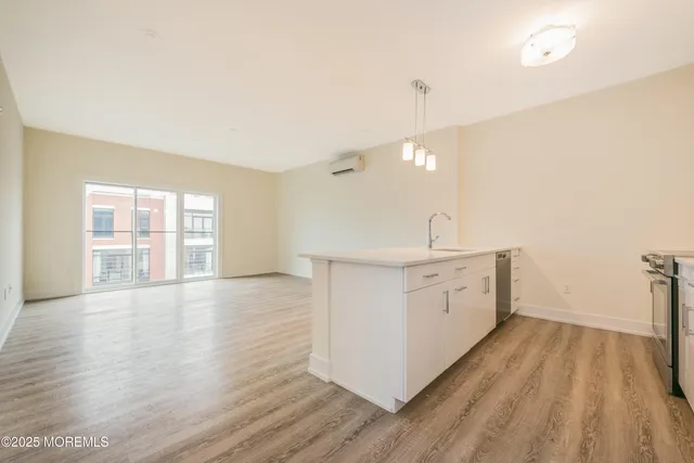 a view of a kitchen with wooden floor and a sink
