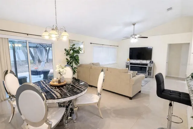 a living room with furniture a chandelier and a flat screen tv