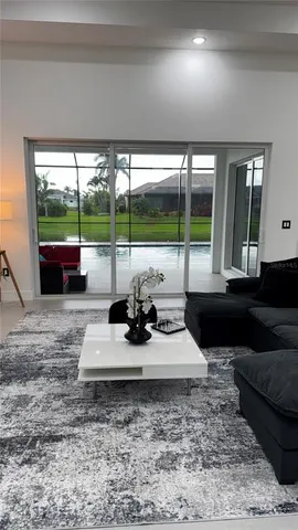 a kitchen with stainless steel appliances granite countertop a sink a oven a stove with chairs and white cabinets