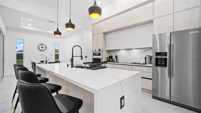 a kitchen with a sink a counter top space appliances and cabinets