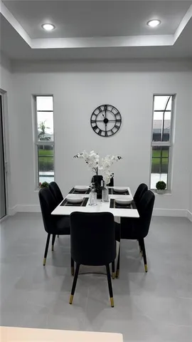 a view of a dining room and kitchen with furniture and a chandelier