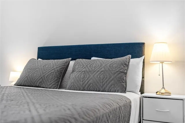 a bedroom with a bed and a painting on the wall