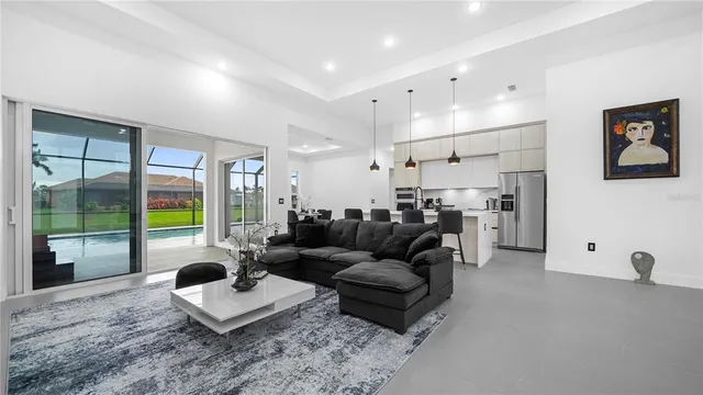 a living room with furniture a flat screen tv and a floor to ceiling window