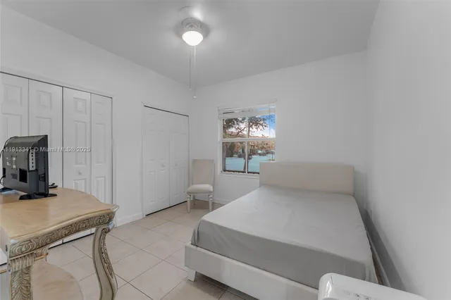 a bedroom with a bed and a ceiling fan