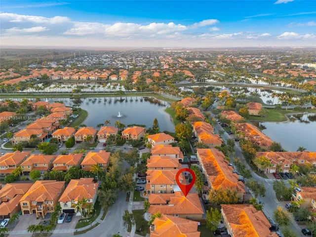 an aerial view of residential houses with outdoor space and lake view