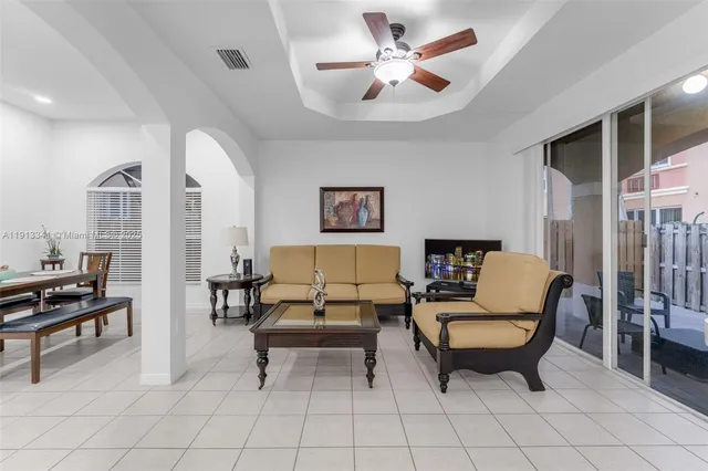a living room with furniture a ceiling fan and a window