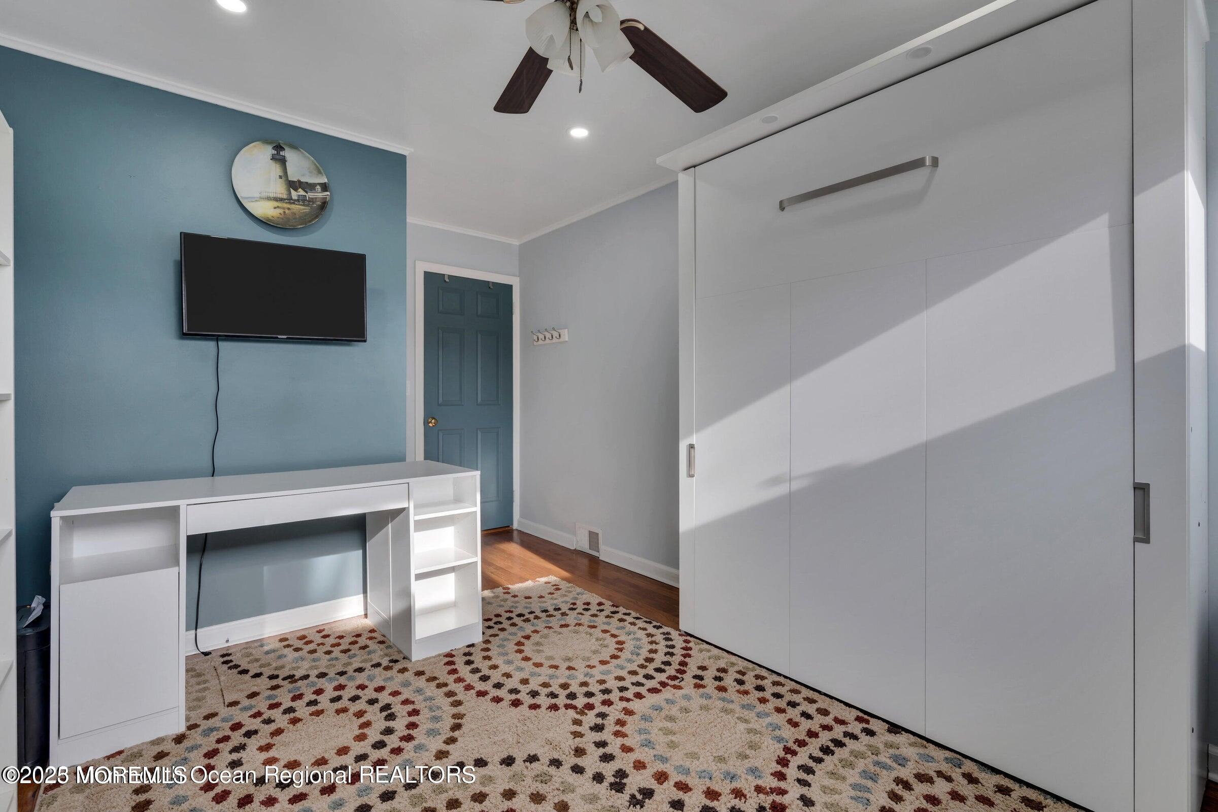 1114 Mohegan Road Manasquan, NJ 08736 - Photo 23 of 28 a living room with a bed and a flat screen tv