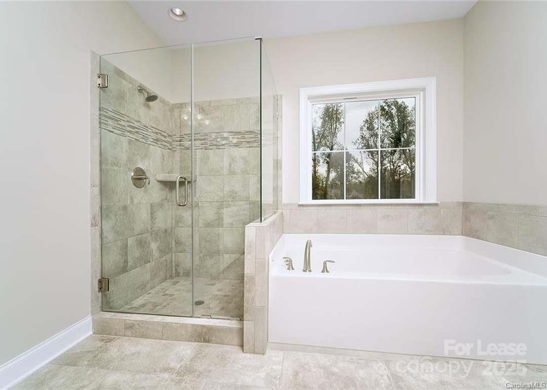 13012 Vermillion Crossing Court Huntersville, NC 28078 - Photo 11 of 18 a white bath tub sitting next to a shower