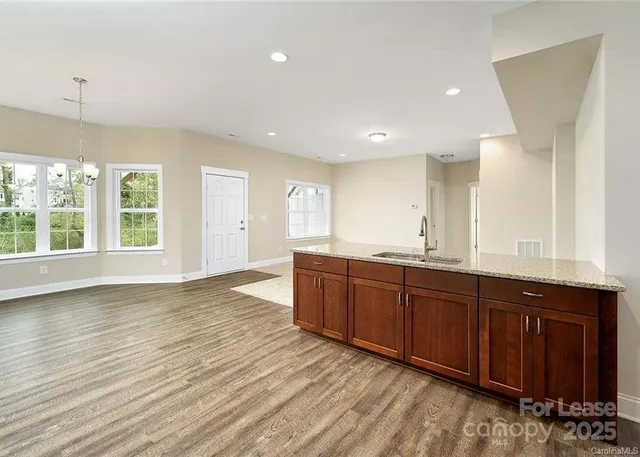 a view of a kitchen counter space with wooden floor and staircase