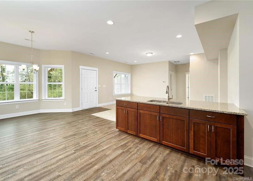 13012 Vermillion Crossing Court Huntersville, NC 28078 - Photo 16 of 18 a view of a kitchen counter space with wooden floor and staircase