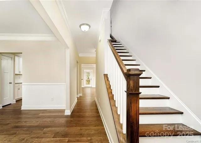 a view of a hallway with wooden floor and staircase
