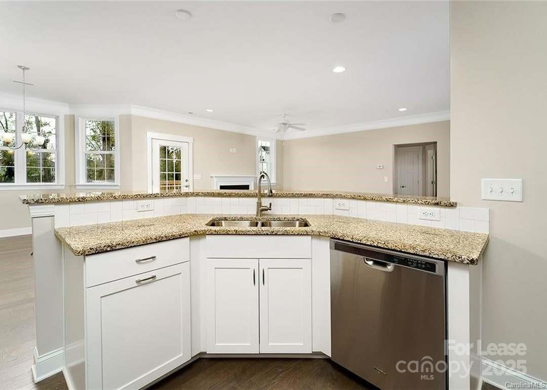 13012 Vermillion Crossing Court Huntersville, NC 28078 - Photo 7 of 18 a kitchen with granite countertop a sink and cabinets
