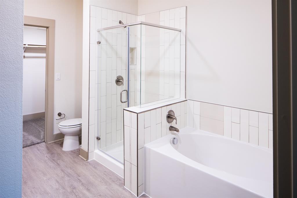 4020 Gilbert Avenue, Unit 101 Dallas, TX 75219 - Photo 6 of 8 a bathroom with a bathtub and a shower