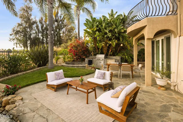 a backyard of a house with fountain table and chairs