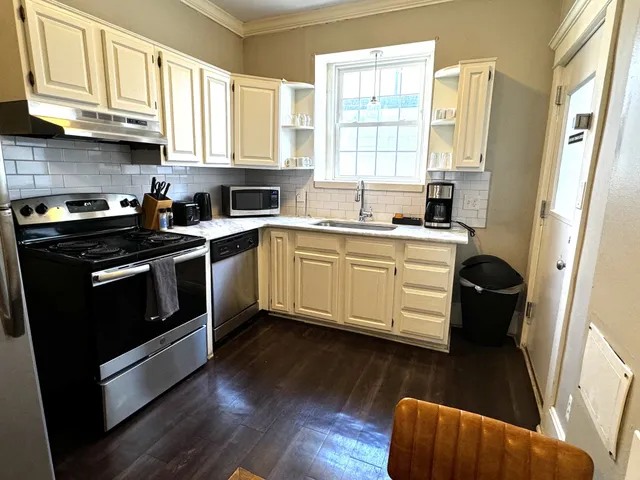 a kitchen with stainless steel appliances granite countertop a stove a sink and a microwave