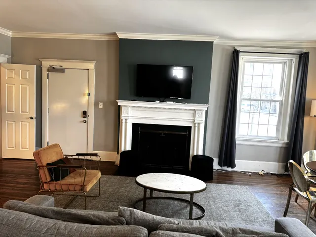 a living room with furniture a flat screen tv and a fireplace