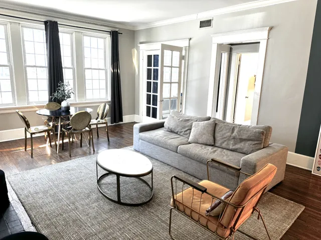 a living room with furniture a wooden floor and a large window
