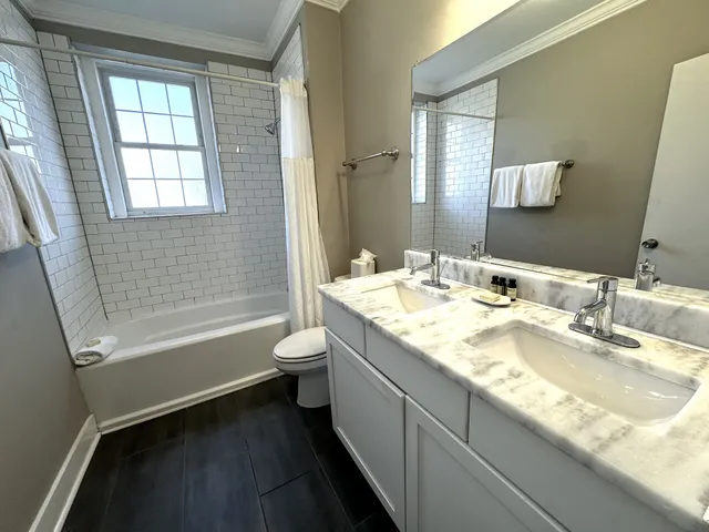a bathroom with a granite countertop sink a toilet and shower