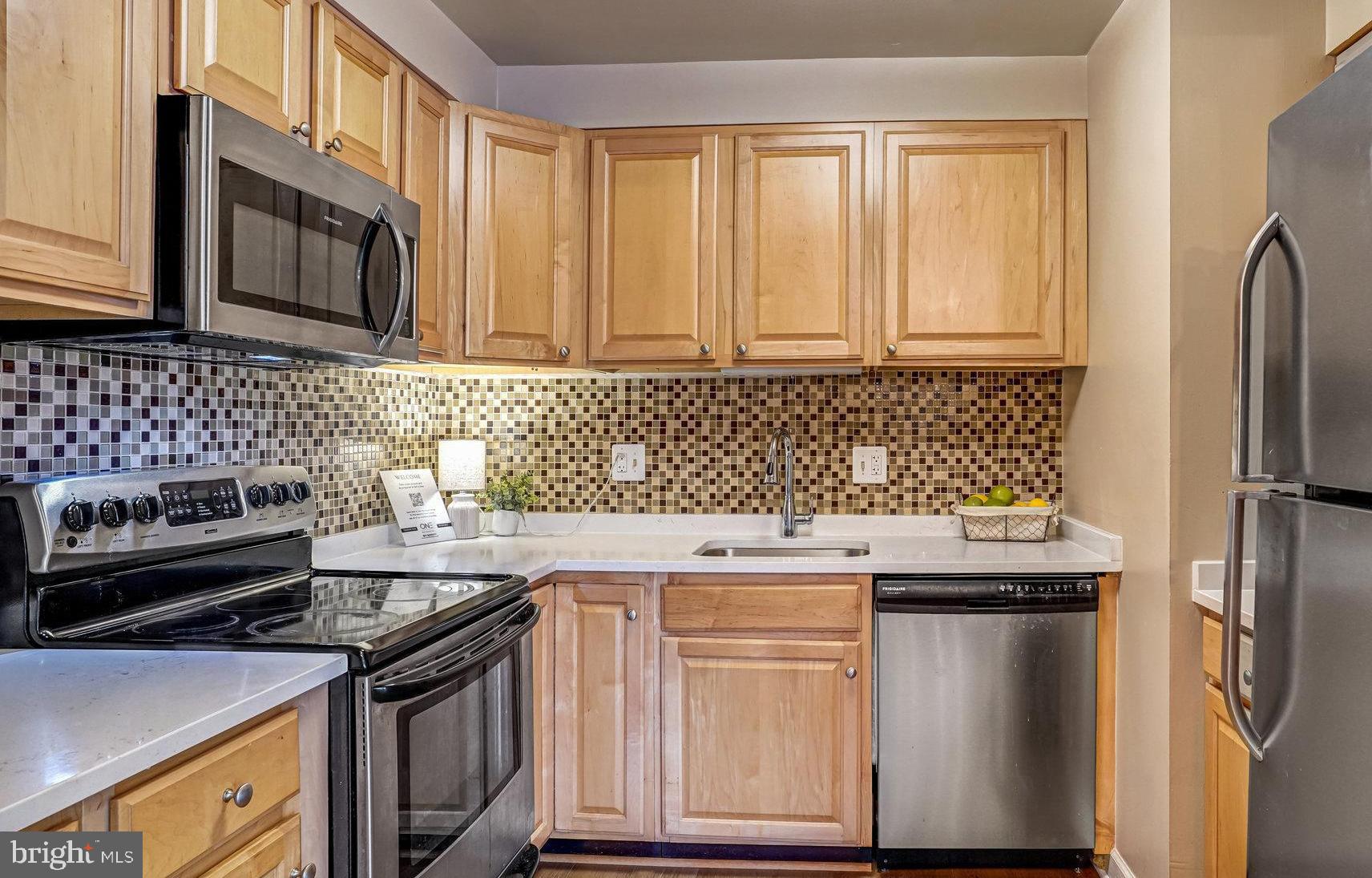 6143 Edsall Road, Unit J Alexandria, VA 22304 - Photo 6 of 23 a kitchen with stainless steel appliances granite countertop a stove a sink and a microwave