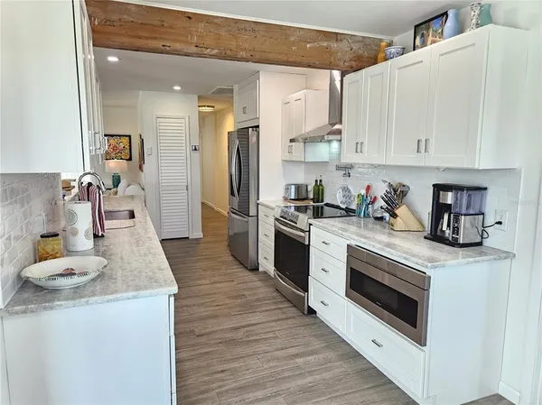 a kitchen with granite countertop a white stove top oven and cabinets