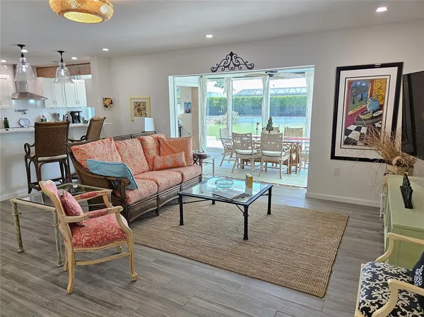 a living room with furniture a wooden floor and next to a window