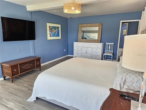 a spacious bedroom with a bed and a flat screen tv