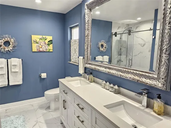 a bathroom with a sink mirror and a toilet
