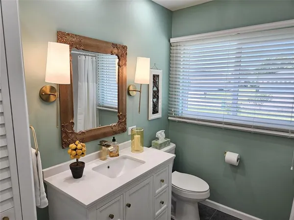 a bathroom with a sink a toilet and mirror