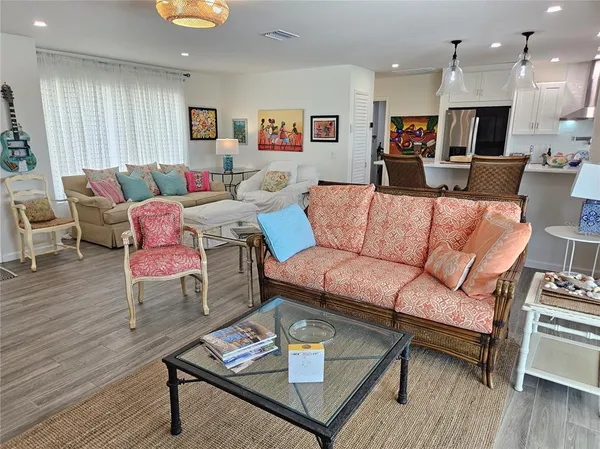 a living room with furniture a wooden floor and a chandelier