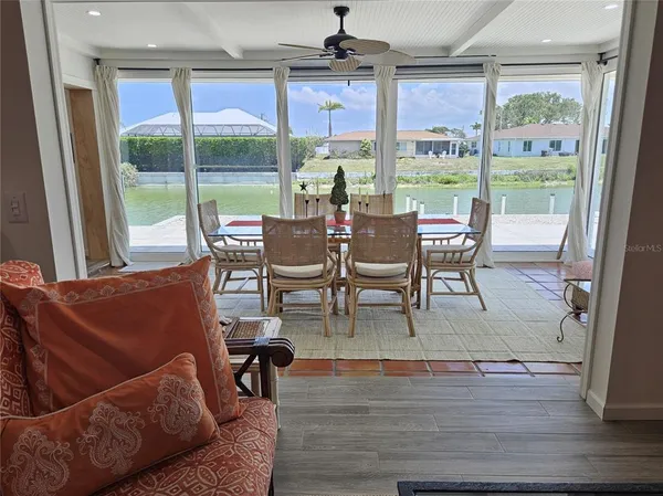 a dining room with furniture a chandelier and wooden floor