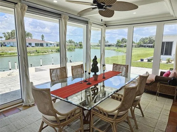 a dining room with furniture large windows and wooden floor