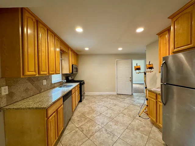 a kitchen with a sink a refrigerator and a stove top oven