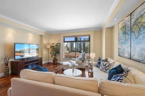 a living room with furniture kitchen view and a large window