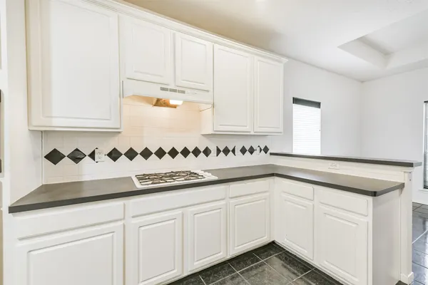 a kitchen with granite countertop white cabinets and a sink