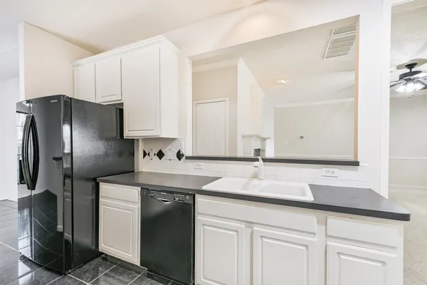 a kitchen with stainless steel appliances granite countertop a sink and a refrigerator