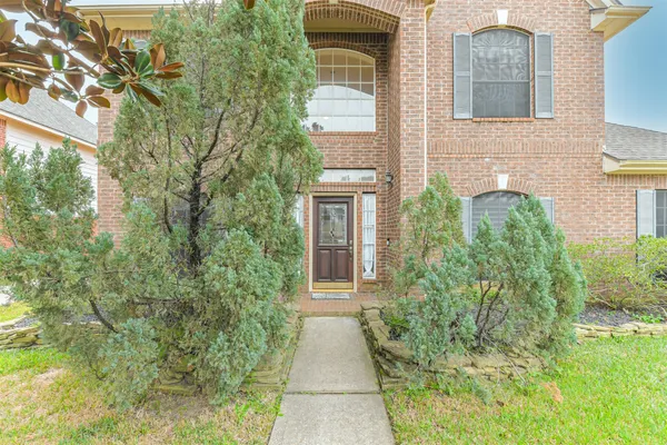 front view of a brick house with a yard
