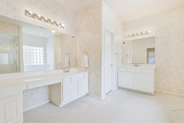 a spacious bathroom with a double vanity sink a mirror and a bathtub