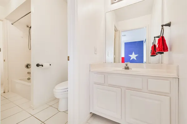 a bathroom with a sink vanity mirror and toilet