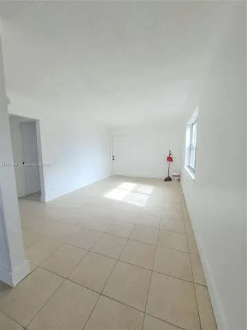 an empty room with white walls and tiles
