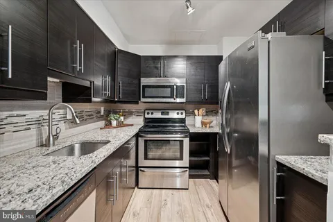 a kitchen with granite countertop a refrigerator and a sink